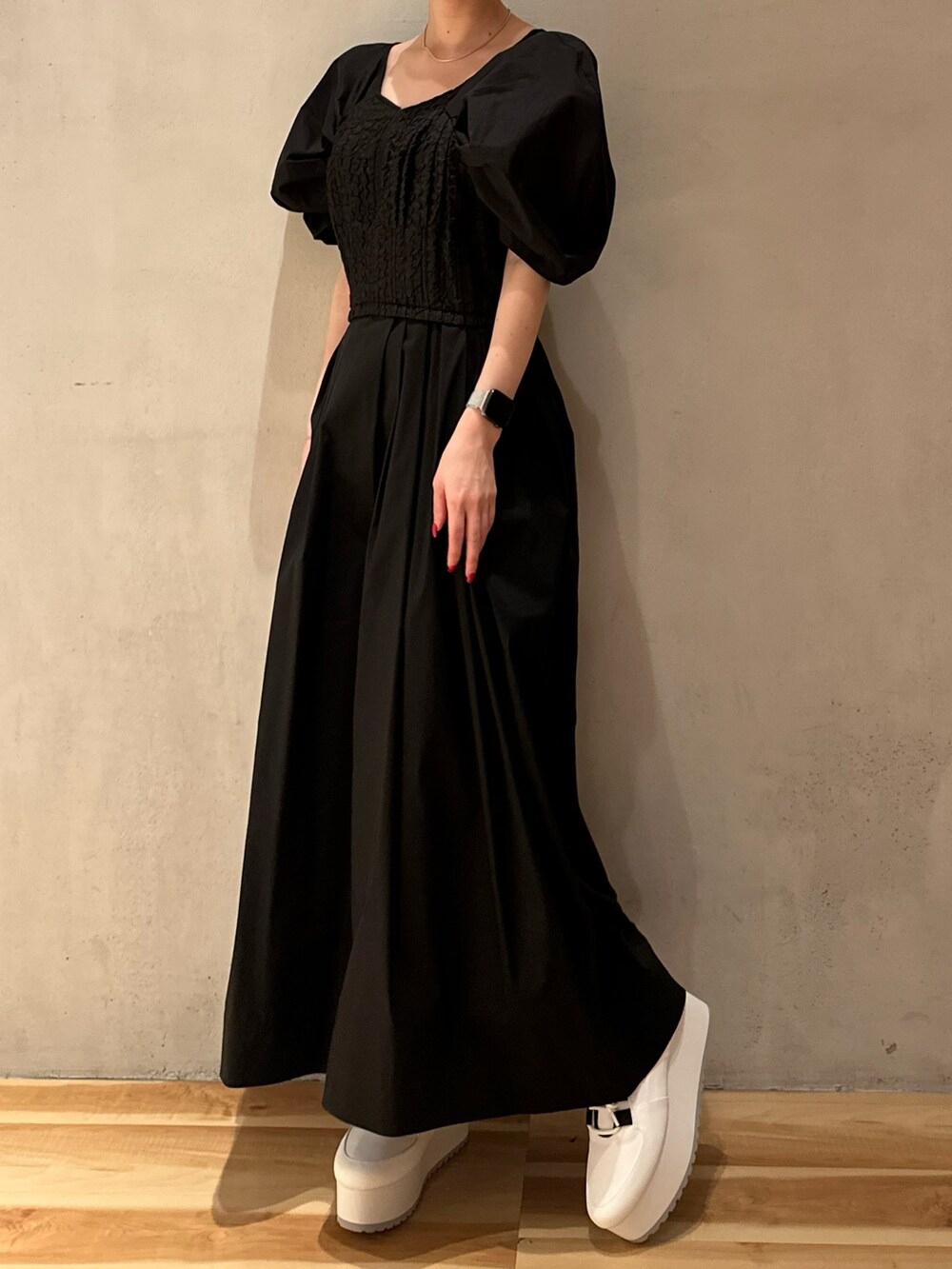 ブラック系のワンピース、ホワイト系のスニーカー、ゴールド系のピアス（両耳用）を着用したレディースの夏コーディネートの5枚目の写真