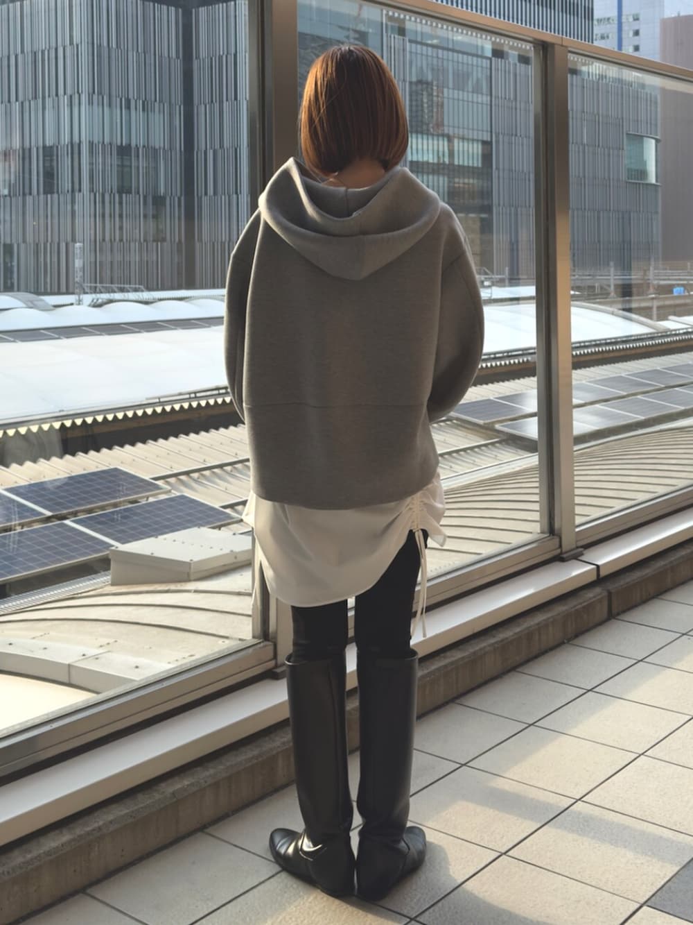 グレー系のパーカー、ブラック系のボストンバッグを着用したレディースの冬コーディネートの5枚目の写真