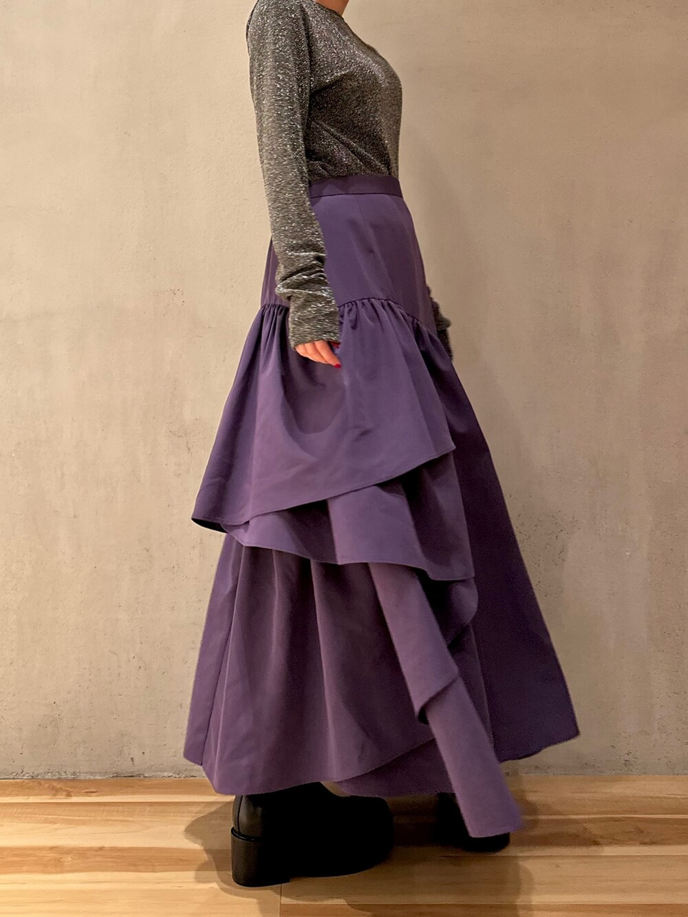 パープル系のスカート、ブラック系のノーカラーコート、シルバー系のTシャツ/カットソーを着用したレディースの秋コーディネートの4枚目の写真