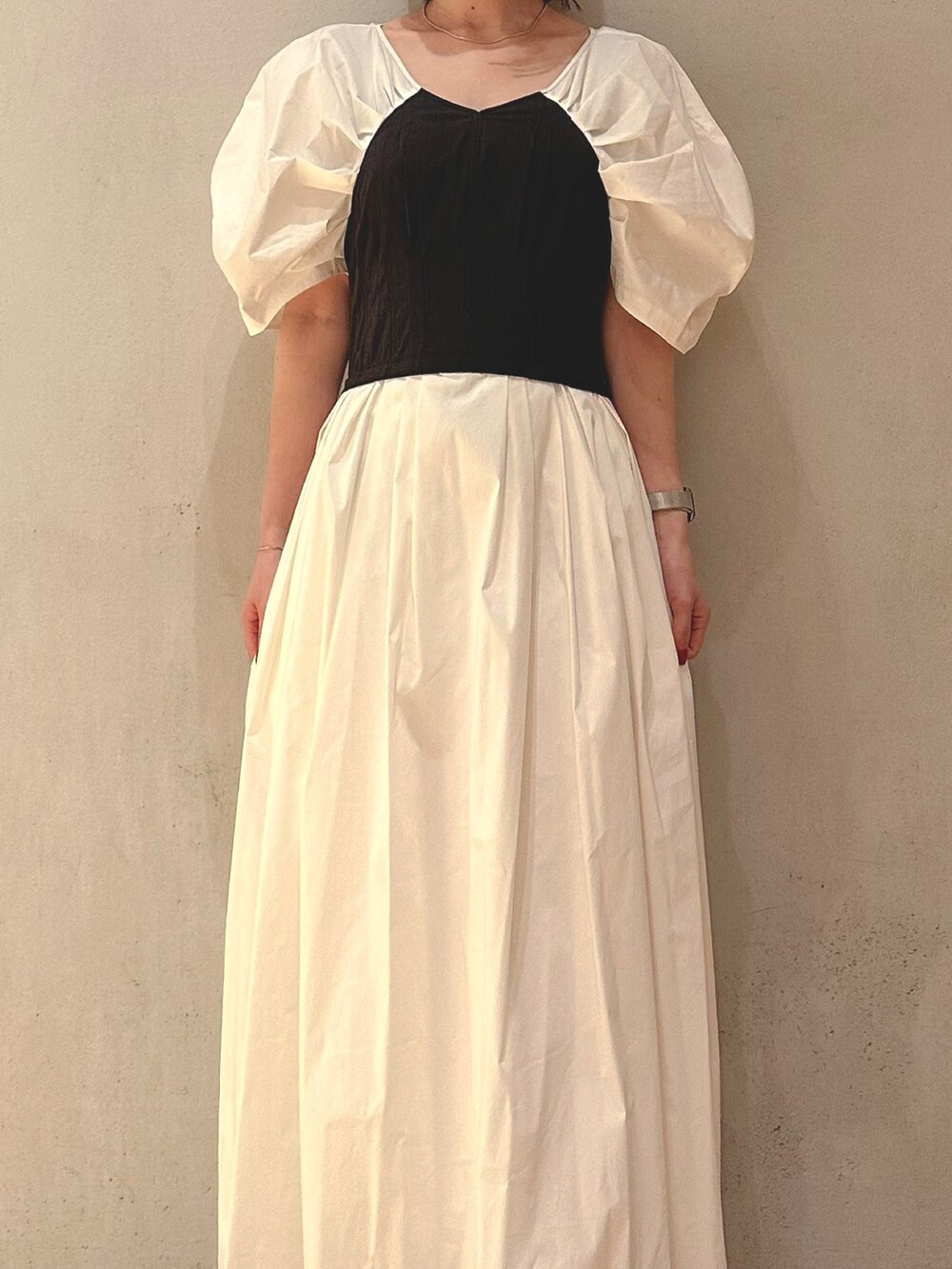 ブラック系のサンダル、ホワイト系のワンピース、ゴールド系のピアス（両耳用）を着用したレディースの夏コーディネートの3枚目の写真