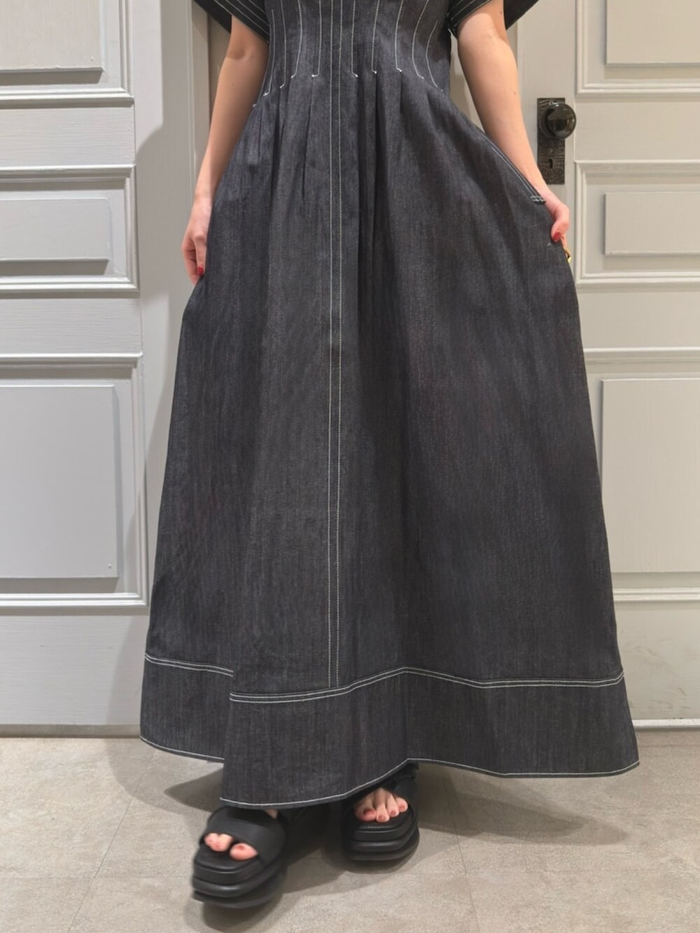 ブルー系のワンピース、ブラック系のサンダルを着用したレディースの春コーディネートの3枚目の写真