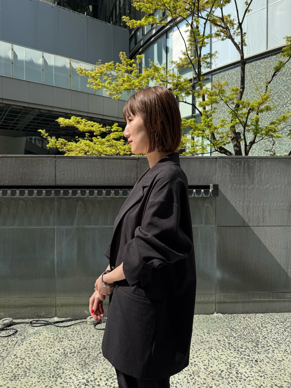 ブラック系のテーラードジャケット、ブラック系のその他パンツ、ゴールド系のサンダルを着用したレディースの春コーディネートの5枚目の写真