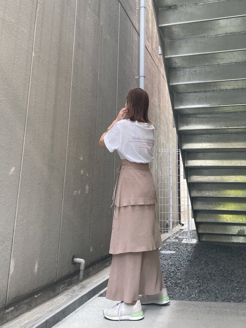 ホワイト系のスニーカー、ベージュ系のスカート、ホワイト系のTシャツ/カットソーを着用したレディースの春コーディネートの5枚目の写真