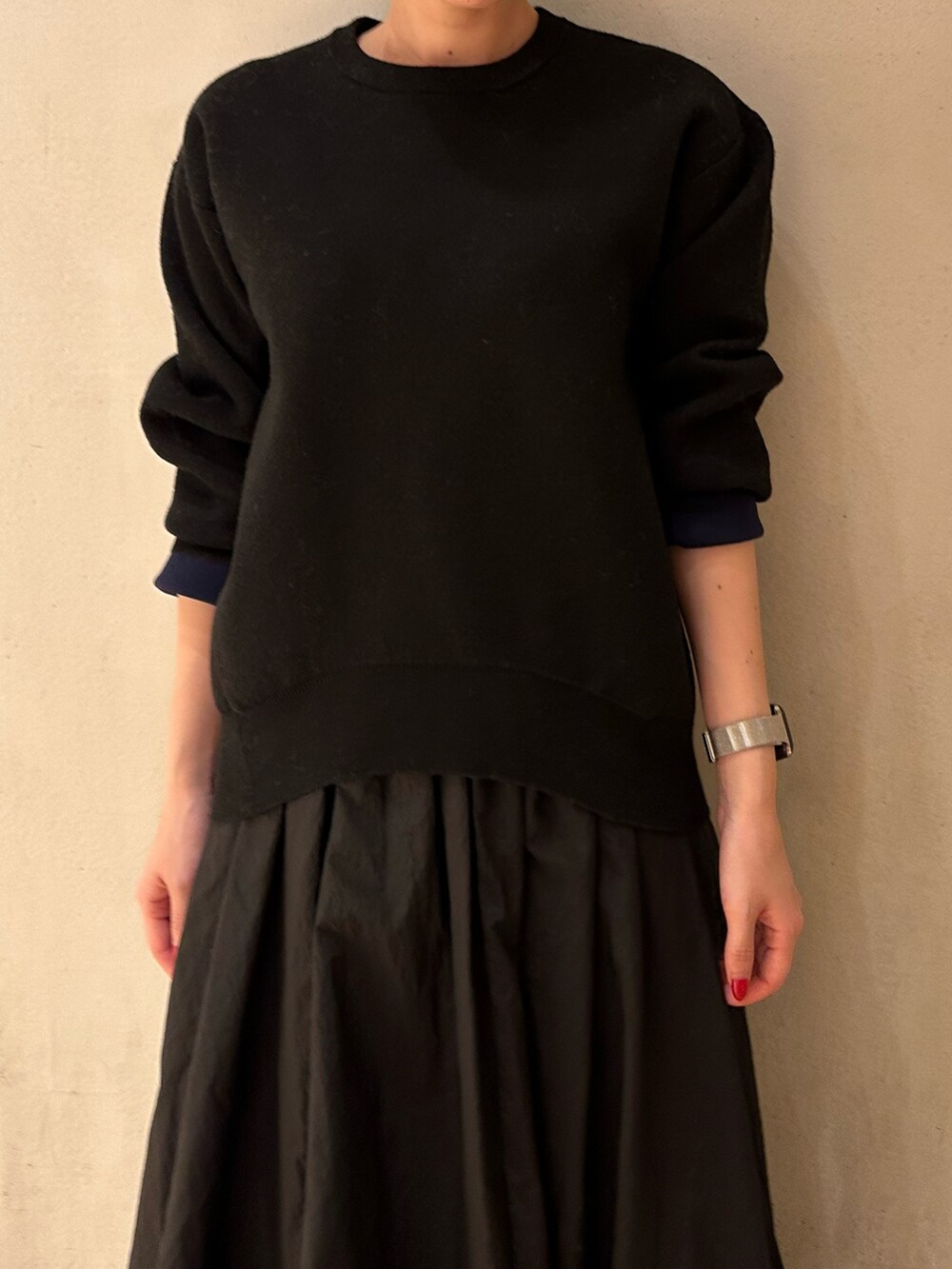 ブラック系のスカート、ブラック系のニット/セーター、ブラック系のブーツを着用したレディースの夏コーディネートの7枚目の写真