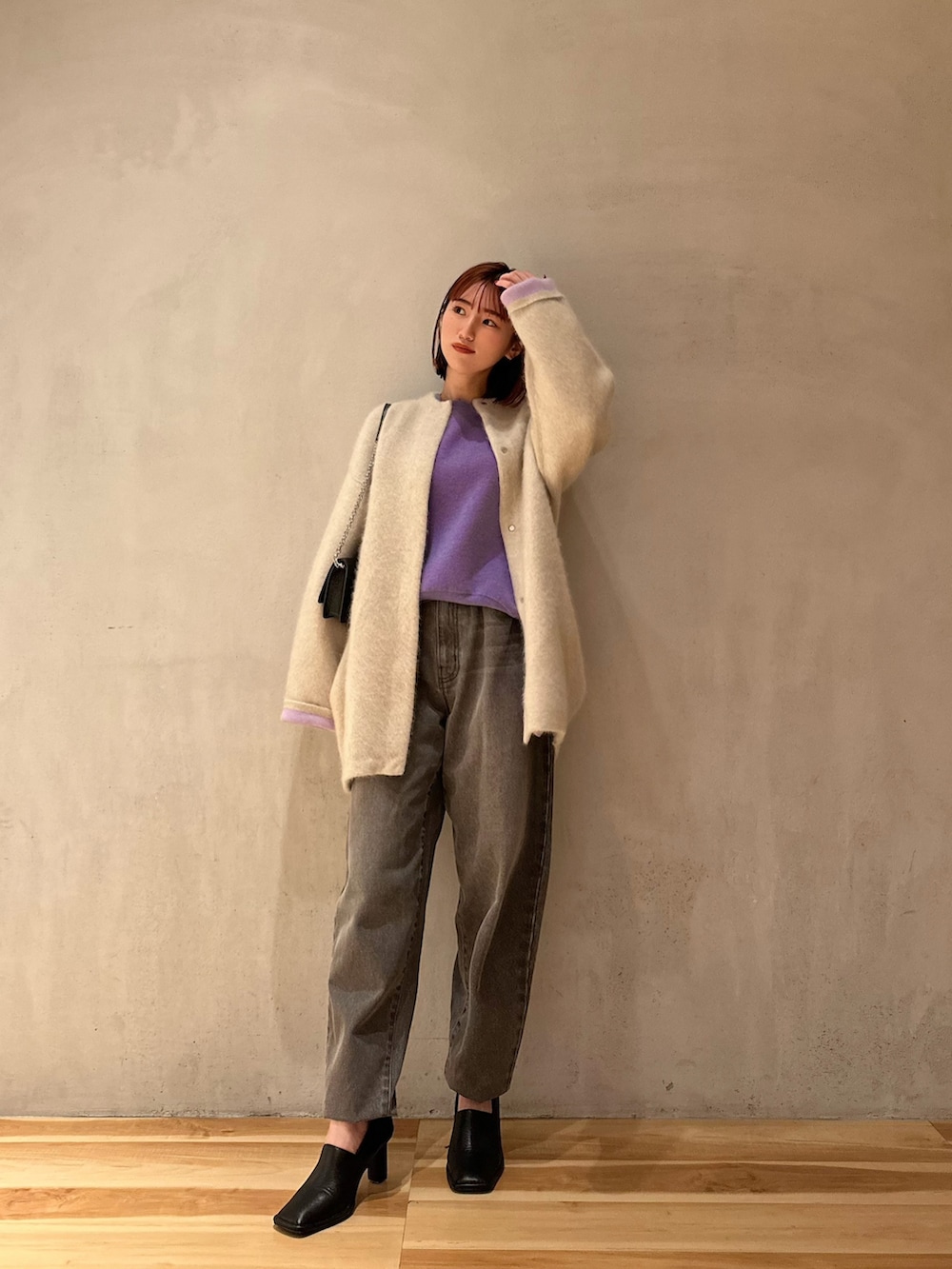 グレー系のデニムパンツ、ブラック系のパンプス、ホワイト系のノーカラージャケットを着用したレディースの夏コーディネートの2枚目の写真