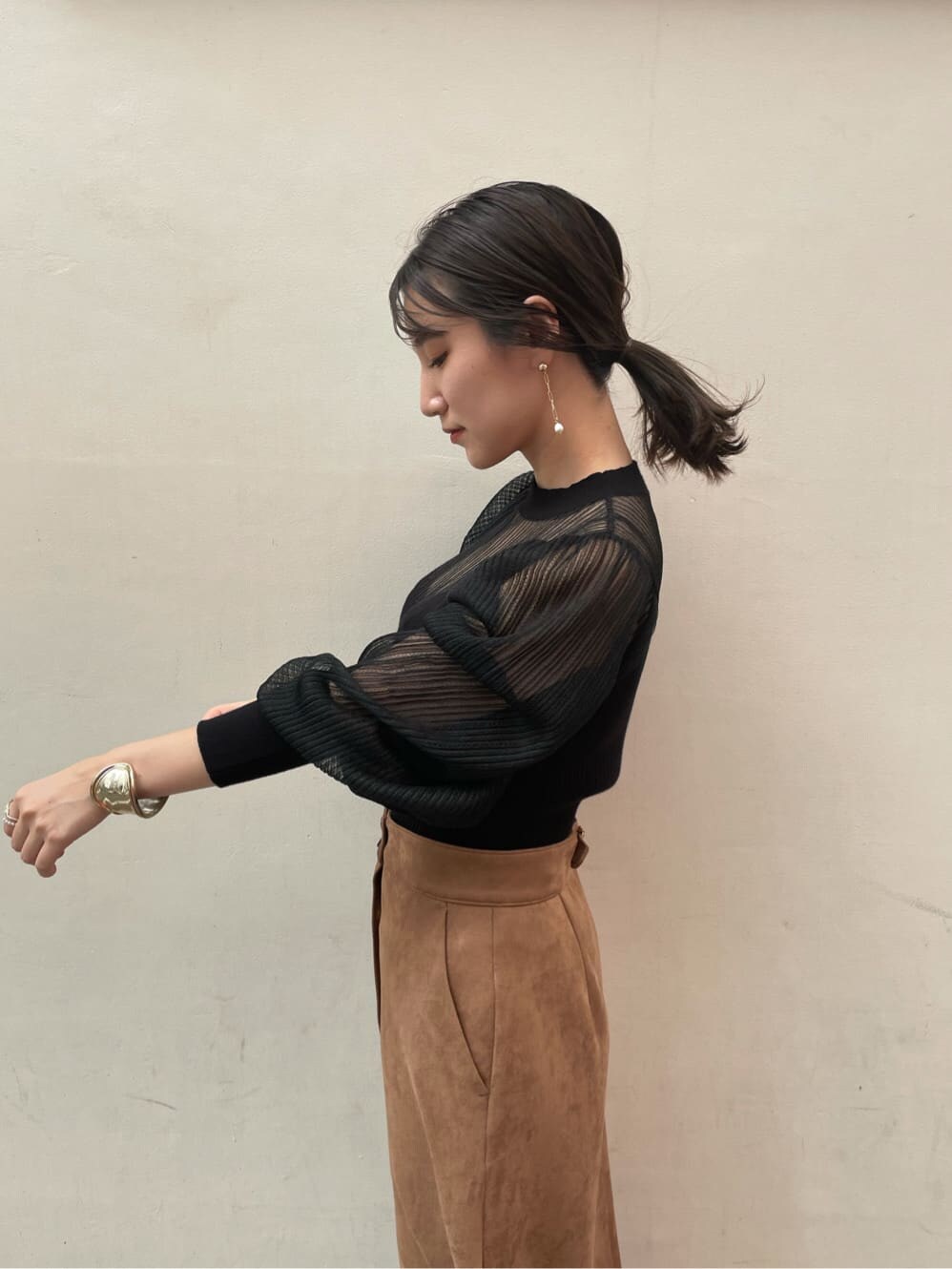 ブラウン系のスカート、ブラック系のその他シューズ、ブラック系のニット/セーターを着用したレディースの夏コーディネートの3枚目の写真