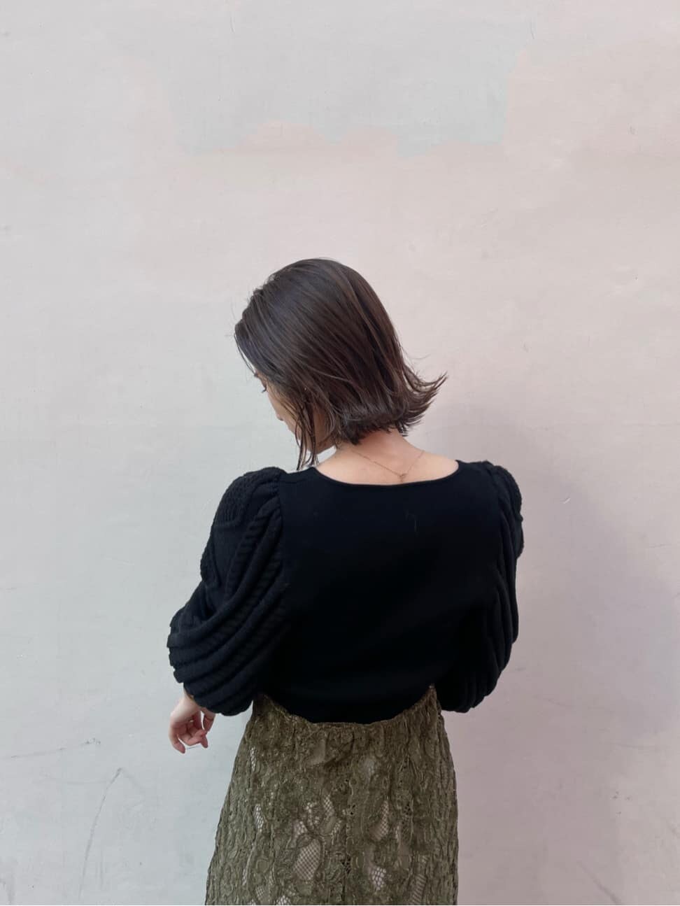 ホワイト系のその他シューズ、ベージュ系のその他アウター、ブラック系のニット/セーターを着用したレディースの冬コーディネートの5枚目の写真