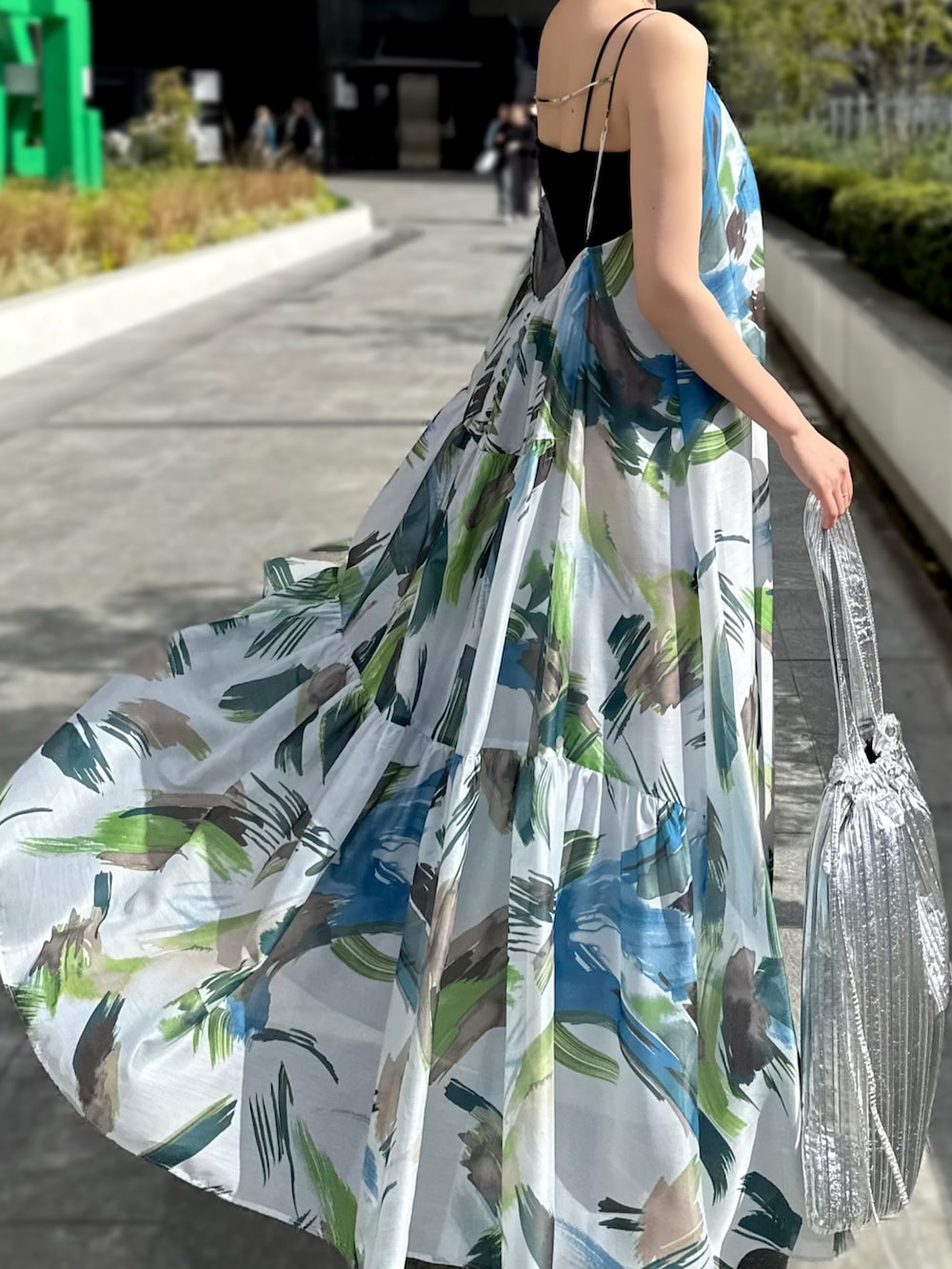 グリーン系のワンピース、シルバー系のトートバッグ、シルバー系のサンダルを着用したレディースの春コーディネートの4枚目の写真