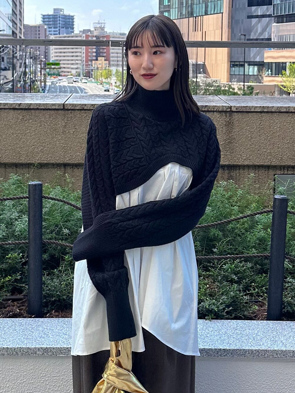 ブラック系のニット/セーター、ブラウン系のその他パンツ、ゴールド系のハンドバッグを着用したレディースの秋コーディネートの6枚目の写真