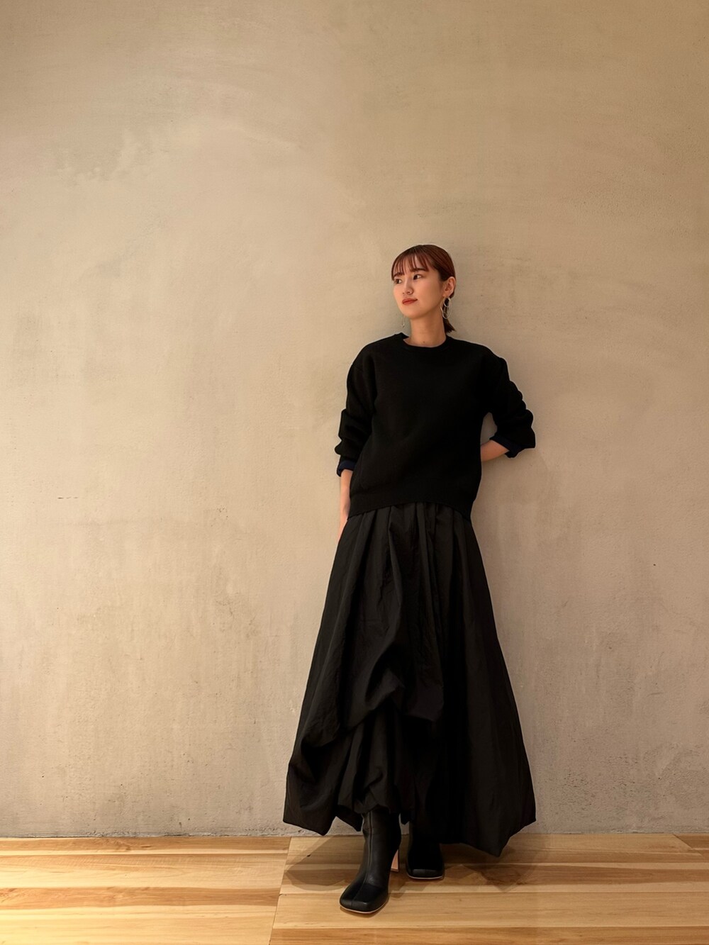 ブラック系のニット/セーター、ブラック系のブーツ、ピンク系のノーカラージャケットを着用したレディースの夏コーディネートの5枚目の写真