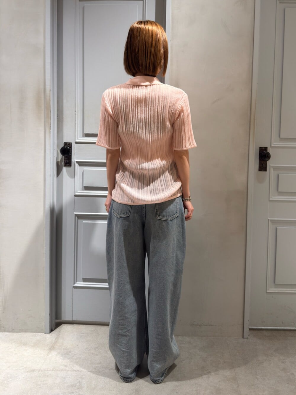 ブルー系のデニムパンツ、ピンク系のニット/セーターを着用したレディースの春コーディネートの3枚目の写真