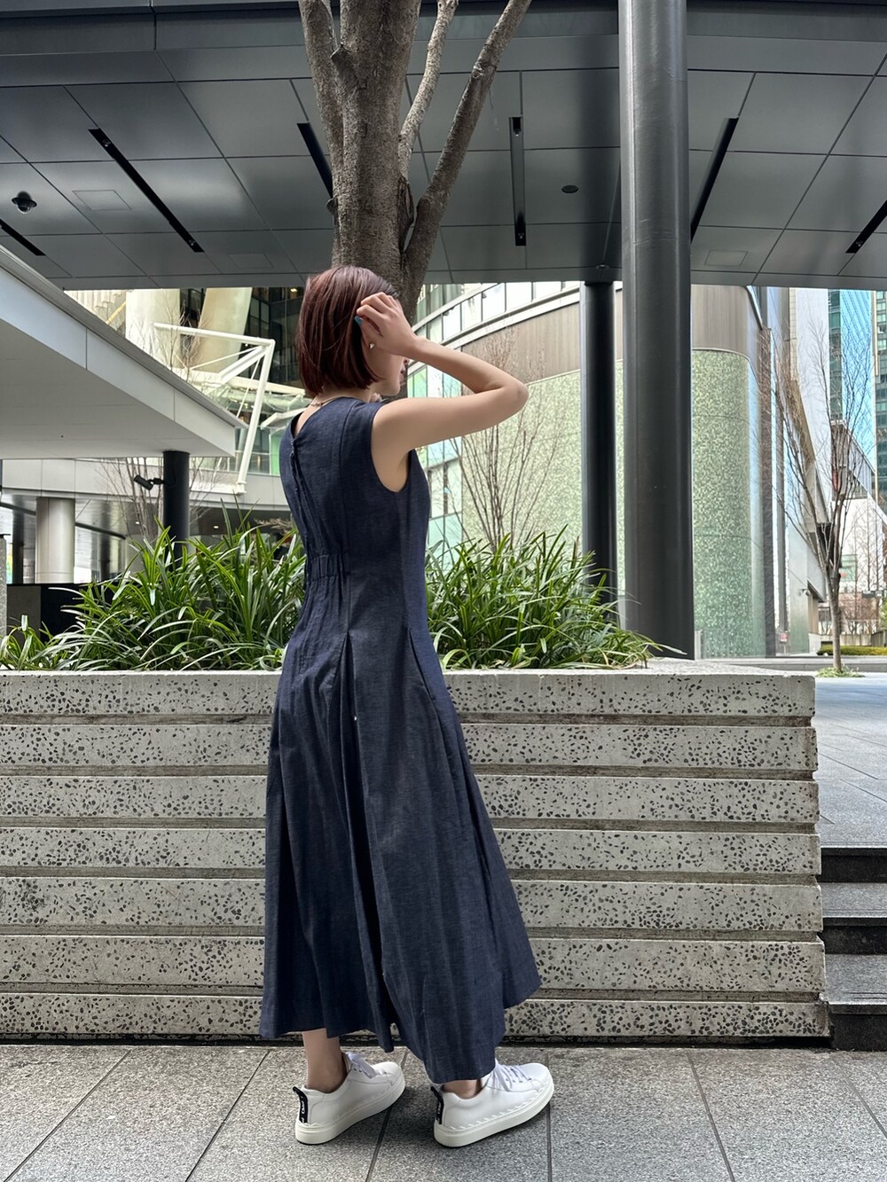 ホワイト系のスニーカー、ブルー系のワンピース、ブラック系のブルゾンを着用したレディースの春コーディネートの7枚目の写真