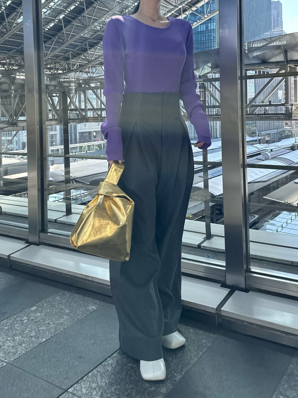 パープル系のニット/セーター、グレー系のその他パンツ、ゴールド系のハンドバッグを着用したレディースの春コーディネートの5枚目の写真