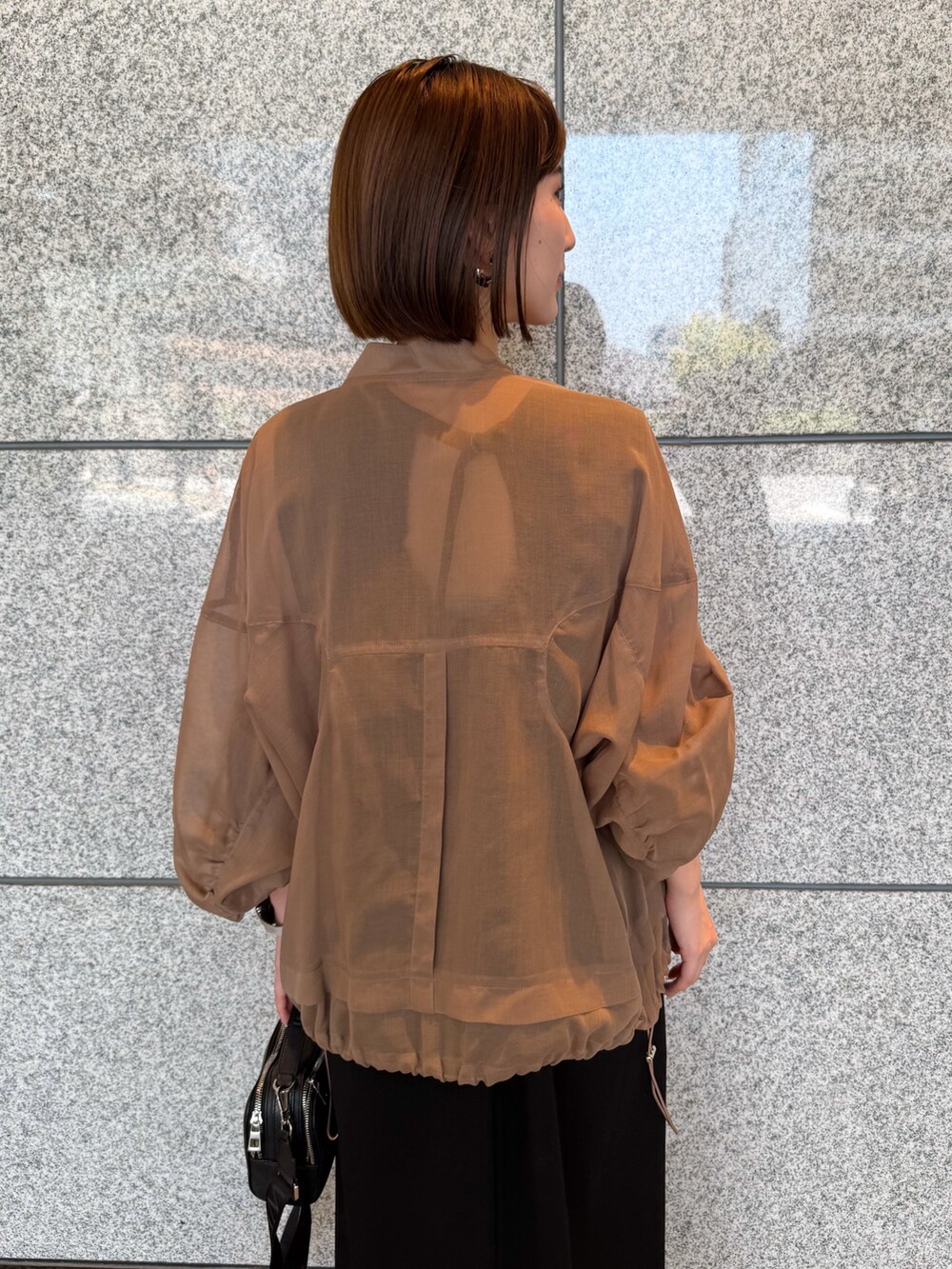 ベージュ系のブルゾン、ブラック系のワンピース、ブラック系のサングラスを着用したレディースの夏コーディネートの5枚目の写真