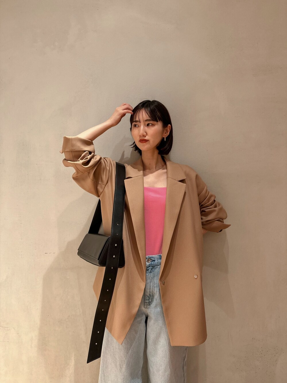 ブルー系のデニムパンツ、ブラック系のパンプス、ブラック系のショルダーバッグを着用したレディースの冬コーディネートの5枚目の写真