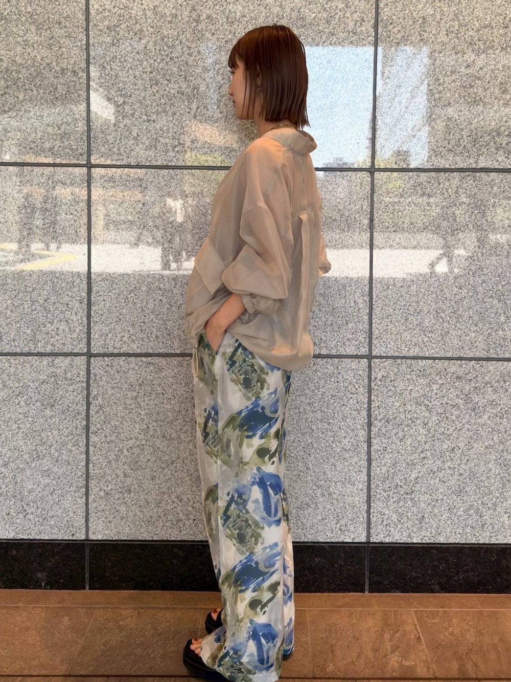 ベージュ系のブルゾン、ブルー系のその他パンツ、ブラウン系のサンダルを着用したレディースの春コーディネートの2枚目の写真