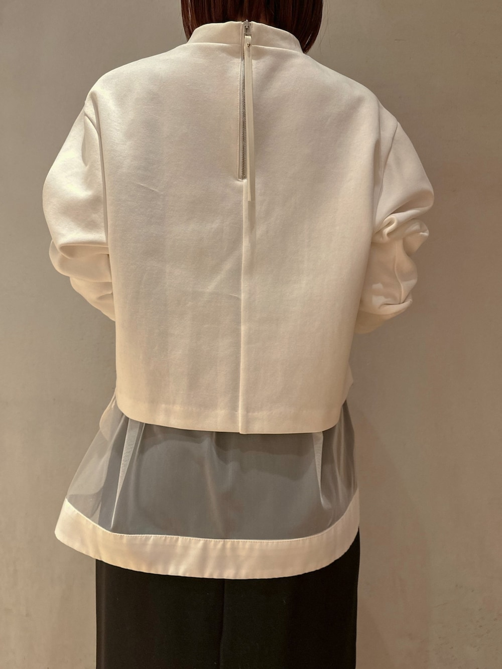 ホワイト系のTシャツ/カットソー、ブラック系のスカート、ブラック系のスニーカーを着用したレディースの冬コーディネートの4枚目の写真