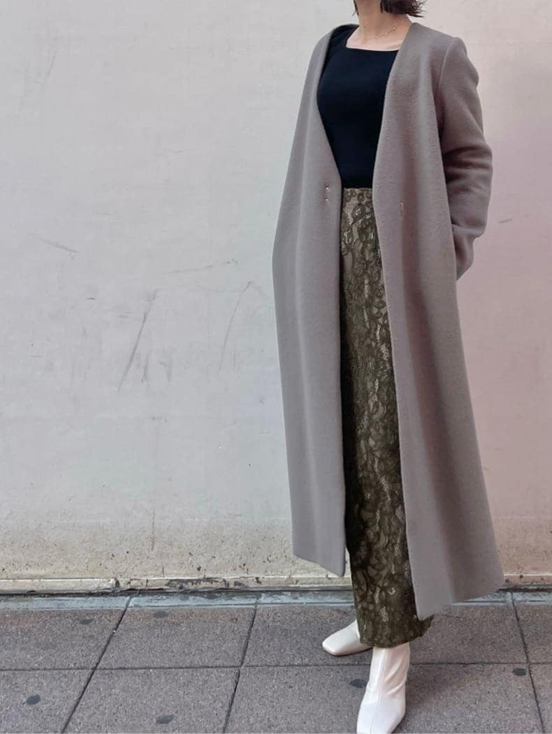 ホワイト系のその他シューズ、ベージュ系のその他アウター、ブラック系のニット/セーターを着用したレディースの冬コーディネートの8枚目の写真