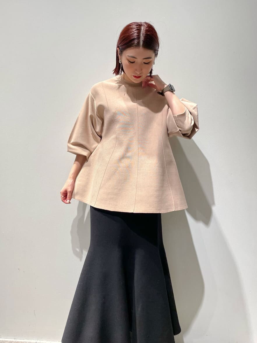 ベージュ系のニット/セーター、ブラウン系のノーカラーコート、ブラック系のブーツを着用したレディースの秋コーディネートの2枚目の写真