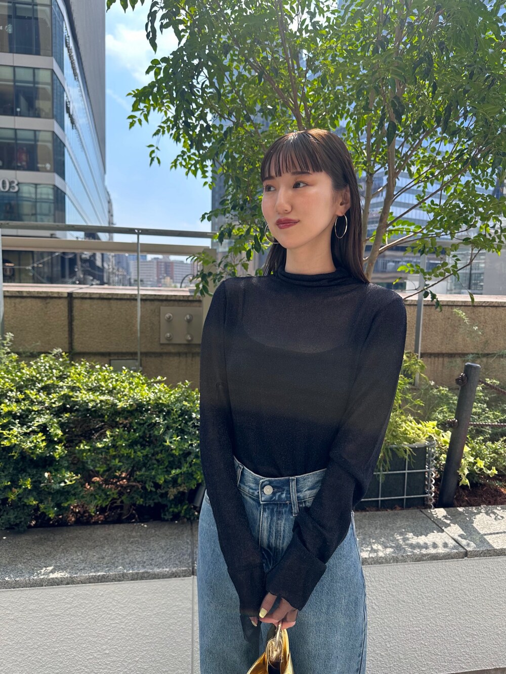 ブルー系のデニムパンツ、ブラック系のパンプス、ブラック系のニット/セーターを着用したレディースの夏コーディネートの5枚目の写真