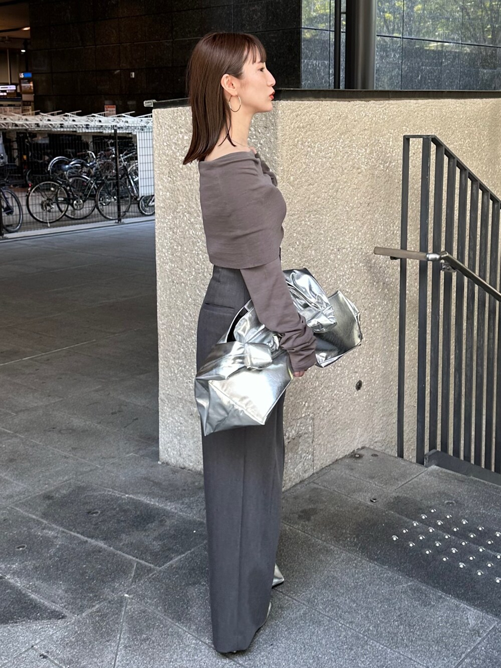 グレー系のニット/セーター、グレー系のその他パンツ、シルバー系のトートバッグを着用したレディースの夏コーディネートの4枚目の写真