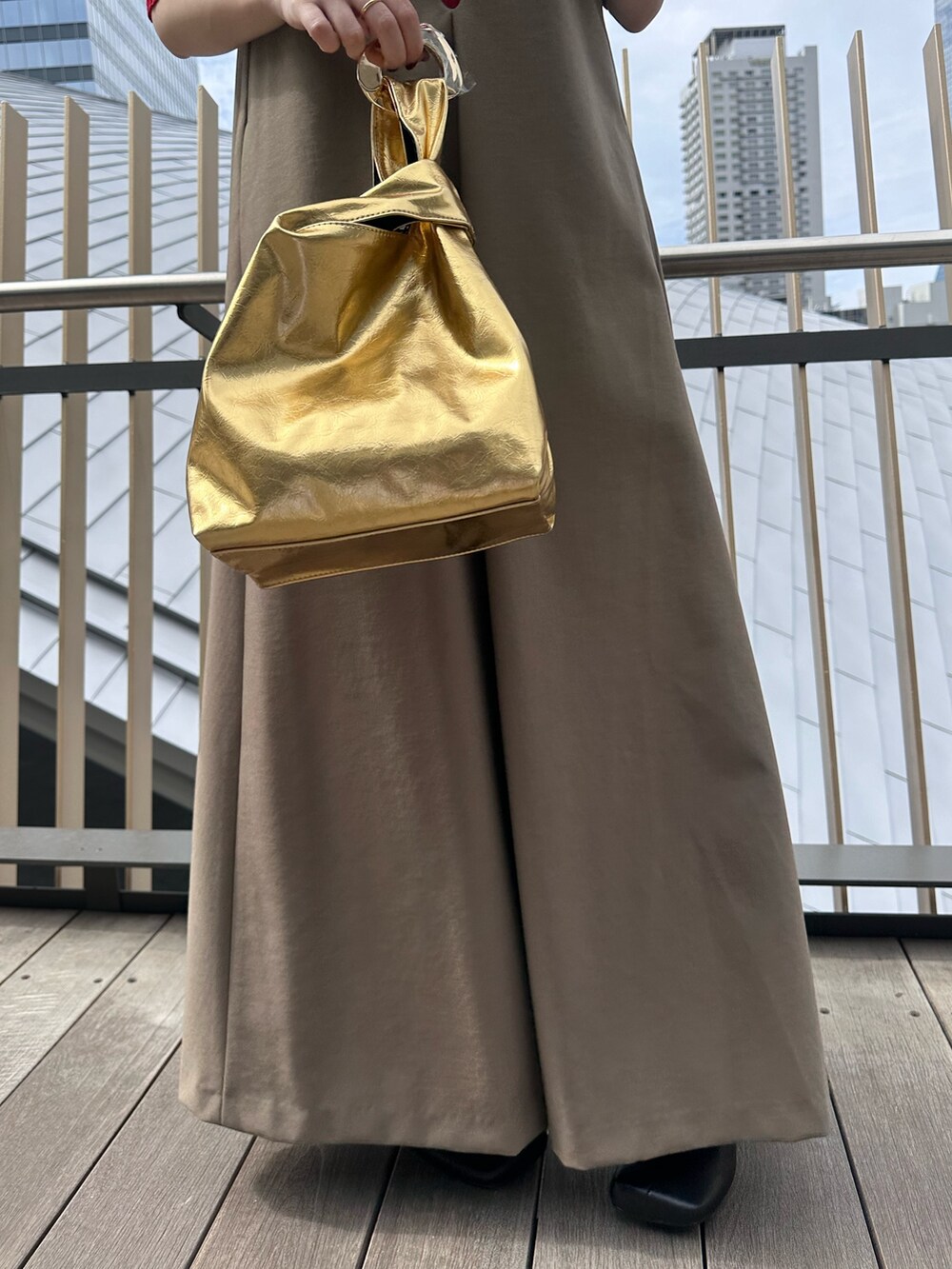 レッド系のニット/セーター、ゴールド系のハンドバッグ、ブラック系のブーツを着用したレディースの秋コーディネートの8枚目の写真