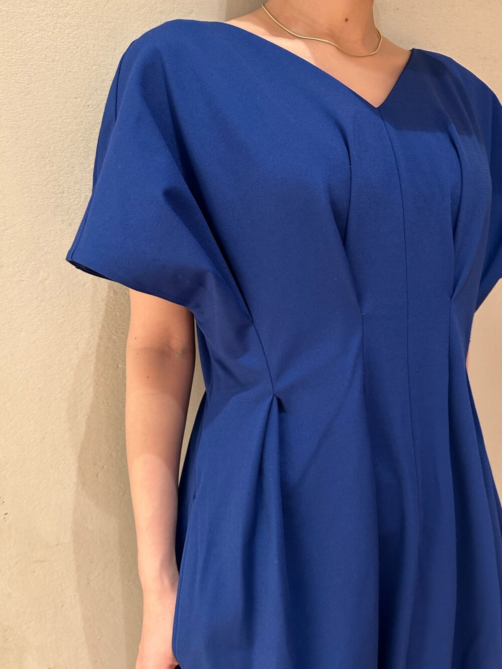 ブルー系のワンピース、ホワイト系のスニーカー、ブラック系のキャップを着用したレディースの春コーディネートの5枚目の写真