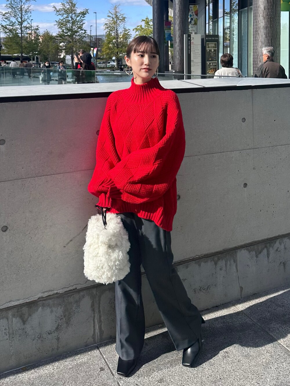 ブラック系のその他アウター、レッド系のニット/セーター、グレー系のその他パンツを着用したレディースの冬コーディネートの6枚目の写真