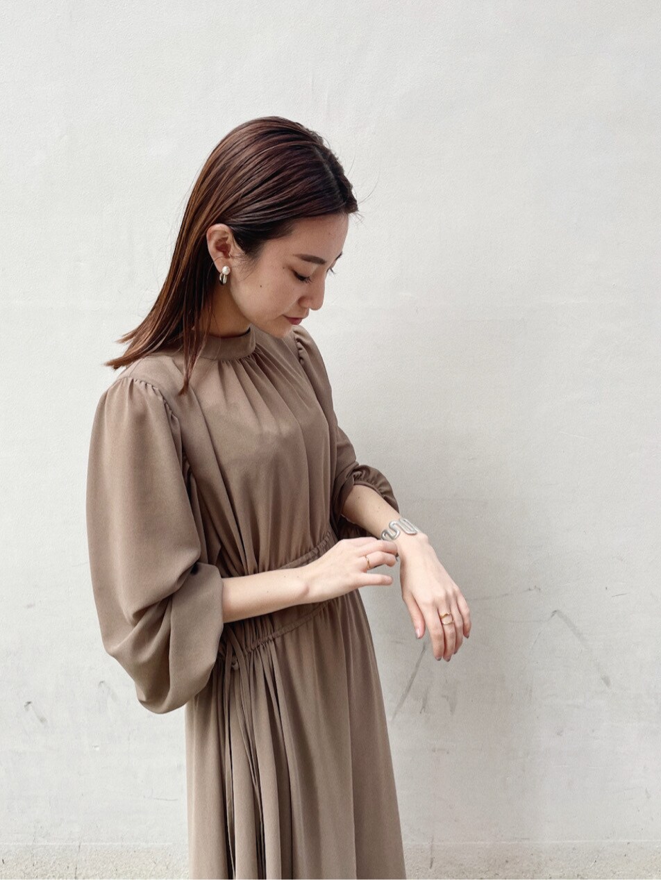 グリーン系のパンプス、ベージュ系のワンピースを着用したレディースの冬コーディネートの3枚目の写真