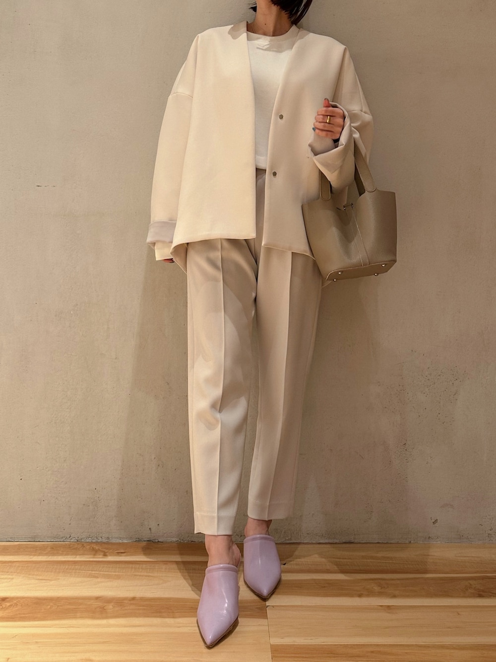 グレー系のその他パンツ、ベージュ系のハンドバッグ、ブラウン系のノーカラーコートを着用したレディースの冬コーディネートの6枚目の写真