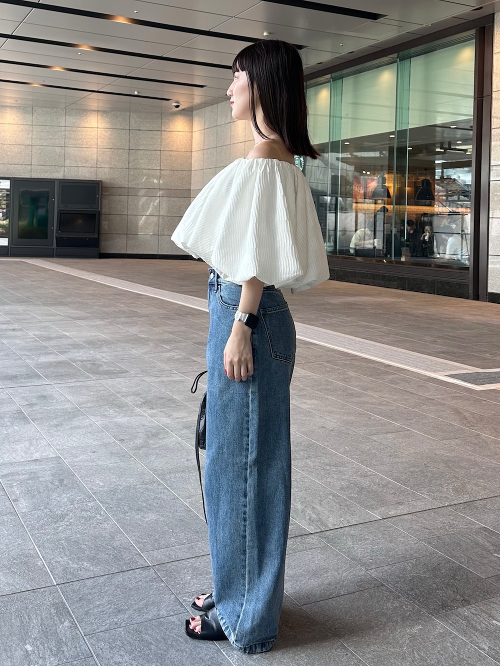 ホワイト系のシャツ/ブラウス、ブルー系のデニムパンツ、ブラック系のショルダーバッグを着用したレディースの夏コーディネートの3枚目の写真