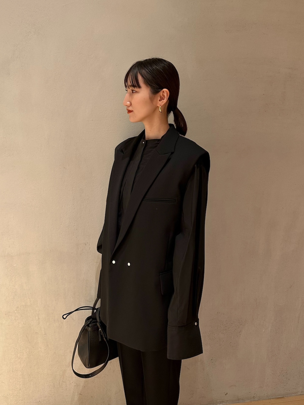 ブラック系のショルダーバッグ、ブラック系のテーラードジャケット、ブラック系のその他パンツを着用したレディースの春コーディネートの3枚目の写真