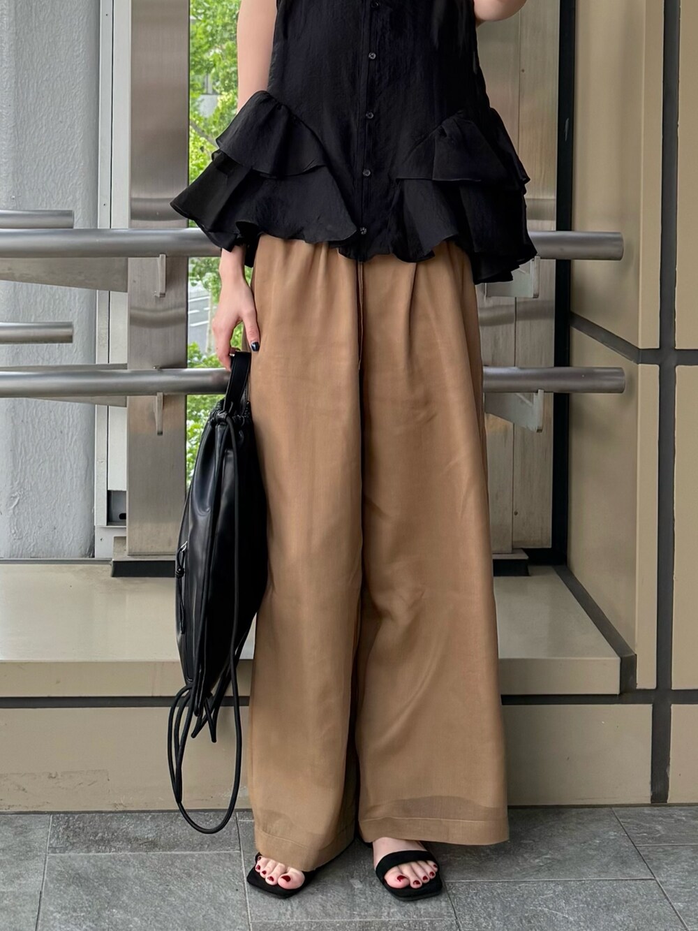 ブラック系のシャツ/ブラウス、ブラウン系のその他パンツ、ブラック系のバックパック/リュックを着用したレディースの春コーディネートの10枚目の写真