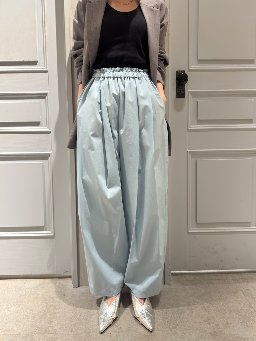 グレー系のテーラードジャケット、グリーン系のその他パンツ、シルバー系のパンプスを着用したレディースの冬コーディネートの4枚目の写真