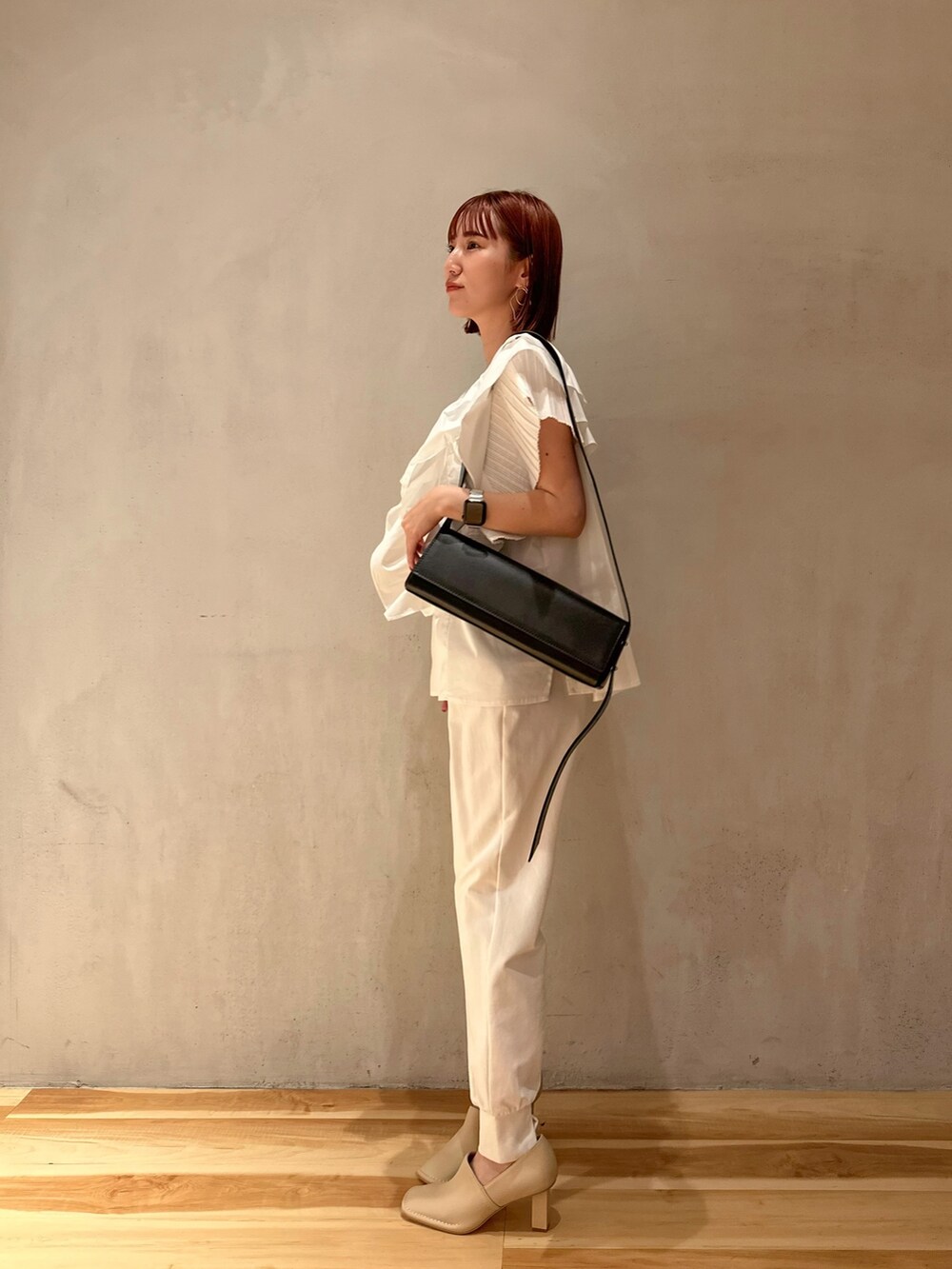 ベージュ系のブーティ、ホワイト系のシャツ/ブラウス、ブラック系のショルダーバッグを着用したレディースの夏コーディネートの3枚目の写真