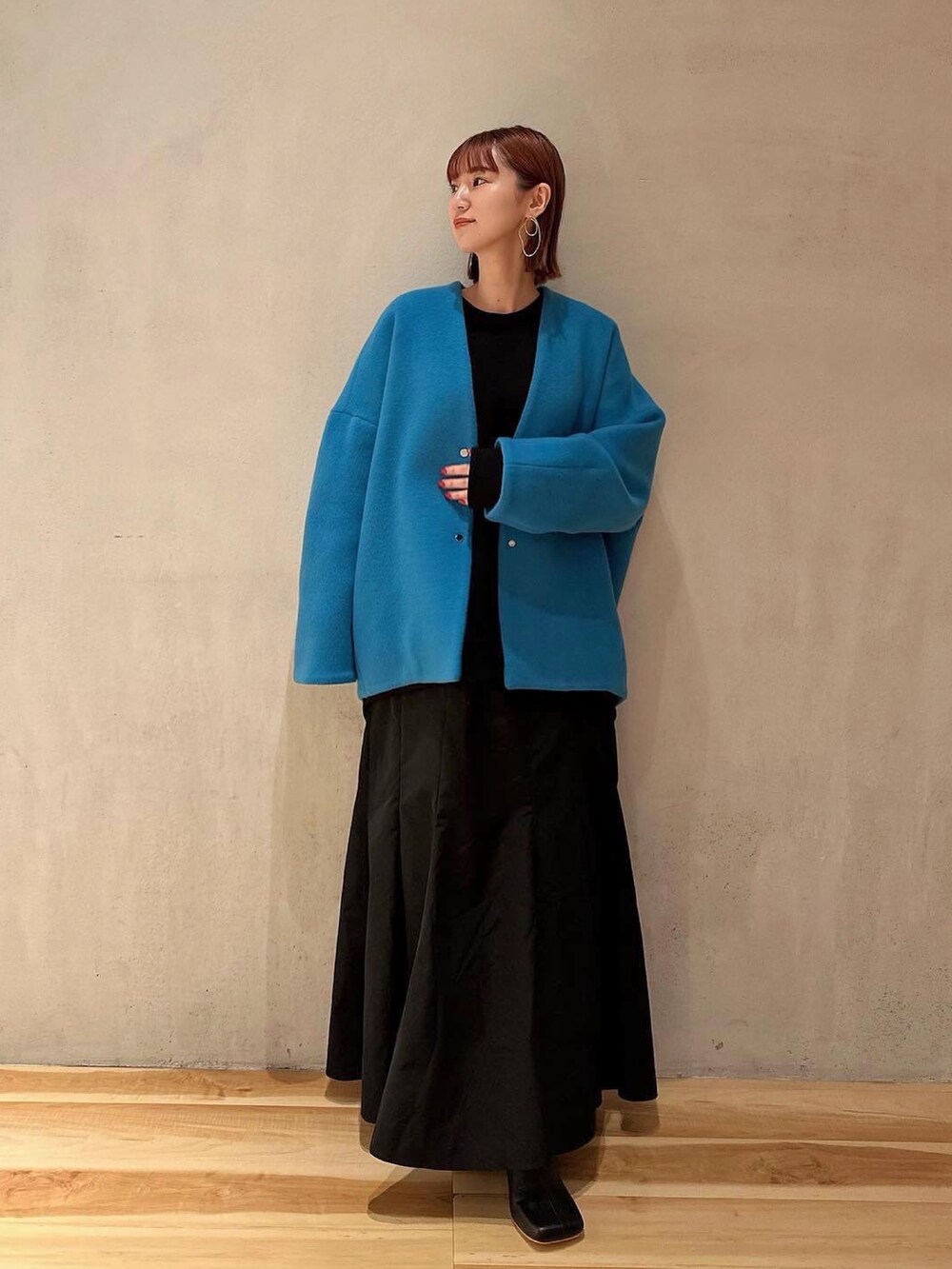 ブルー系のノーカラーコート、ブラック系のブーツ、ブラック系のワンピースを着用したレディースの夏コーディネートの2枚目の写真