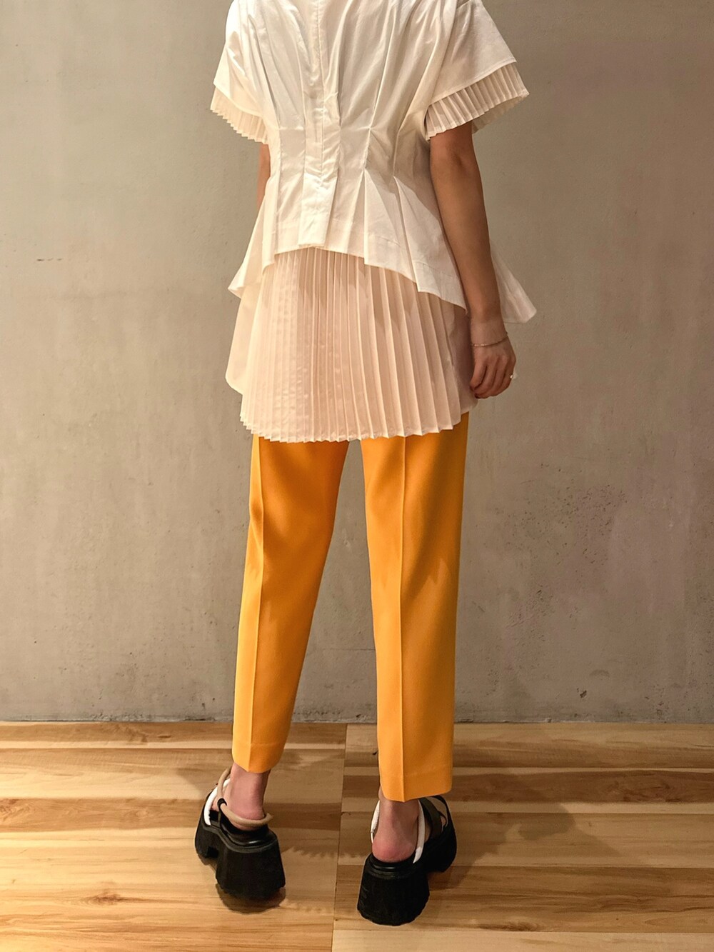 ホワイト系のシャツ/ブラウス、オレンジ系のその他パンツ、その他のサンダルを着用したレディースの冬コーディネートの5枚目の写真