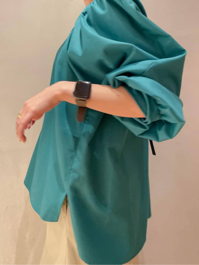 ベージュ系のスカート、ブルー系のスニーカー、グリーン系のシャツ/ブラウスを着用したレディースの秋コーディネートの5枚目の写真