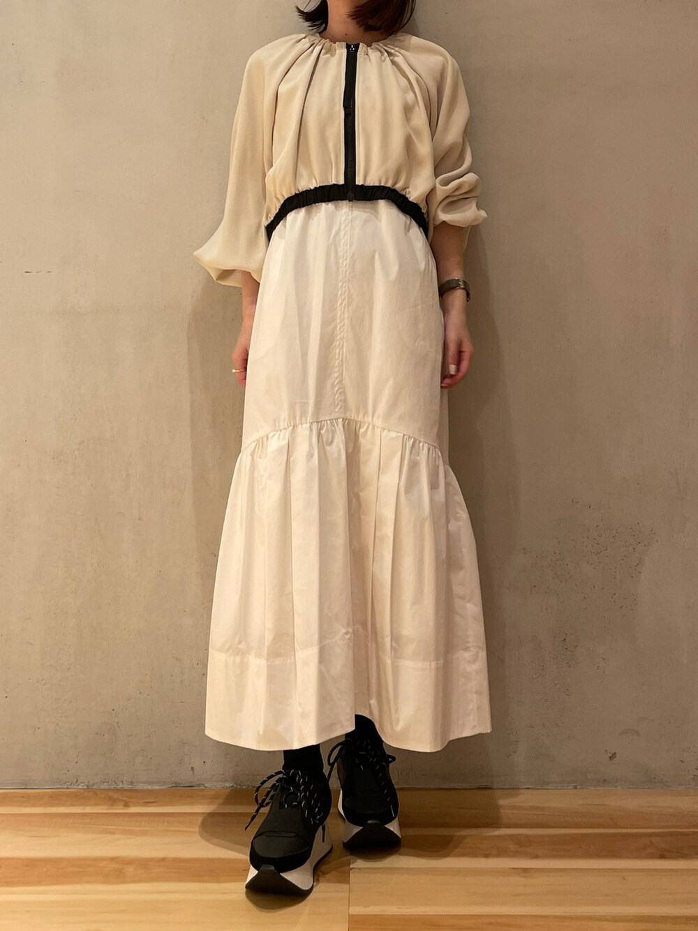 ホワイト系のワンピース、ブラック系のスニーカー、パープル系のスマホケース/カバーを着用したレディースの冬コーディネートの3枚目の写真