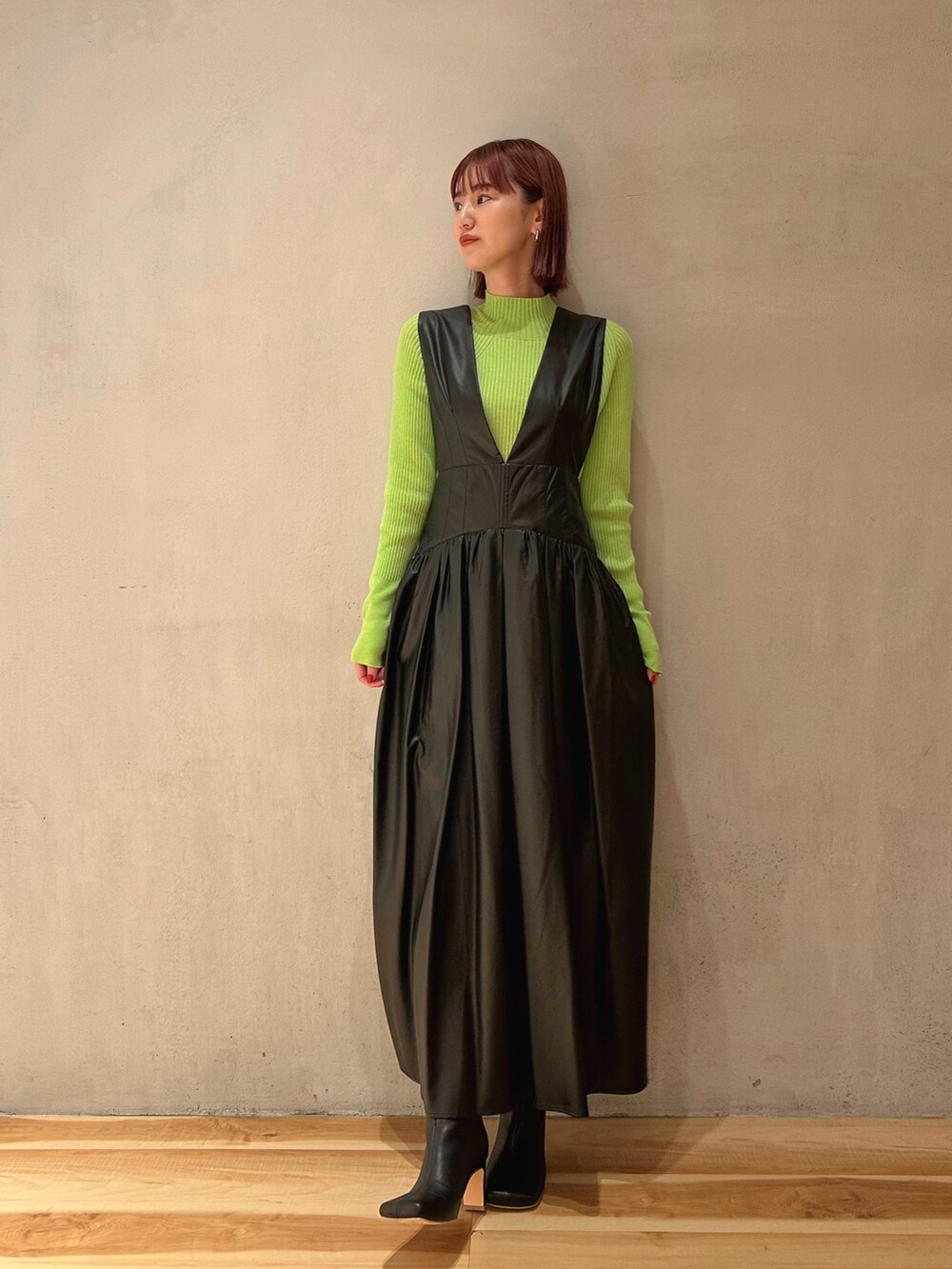 ブラック系のブーツ、ブラック系のジャンパースカート、パープル系のニット/セーターを着用したレディースの秋コーディネートの8枚目の写真