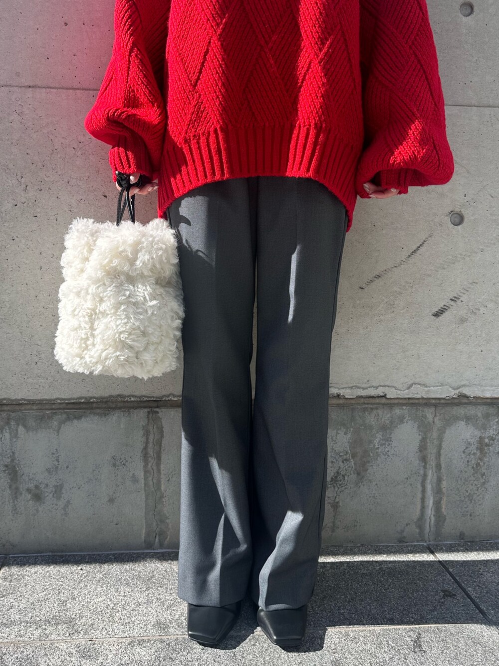 ブラック系のその他アウター、レッド系のニット/セーター、グレー系のその他パンツを着用したレディースの冬コーディネートの9枚目の写真