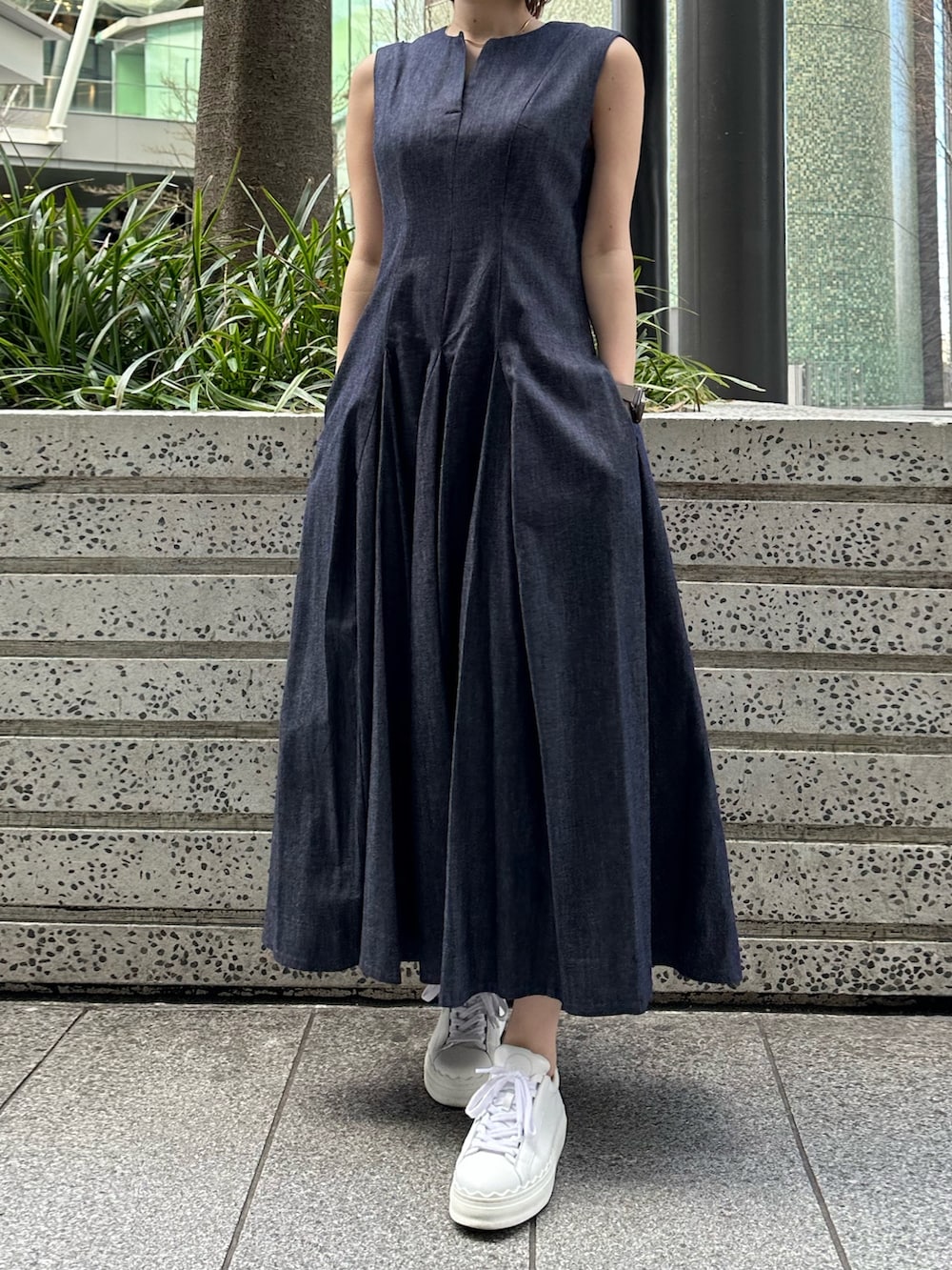 ホワイト系のスニーカー、ブルー系のワンピース、ブラック系のブルゾンを着用したレディースの春コーディネートの6枚目の写真