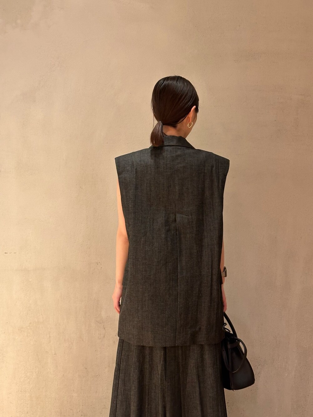 ゴールド系のパンプス、イエロー系のタンクトップ、その他のテーラードジャケットを着用したレディースの春コーディネートの6枚目の写真