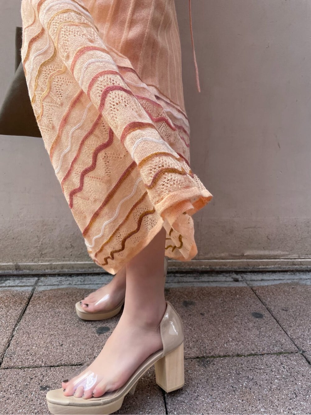 オレンジ系のワンピース、その他のパンプス、シルバー系のバングル/リストバンドを着用したレディースの春コーディネートの8枚目の写真