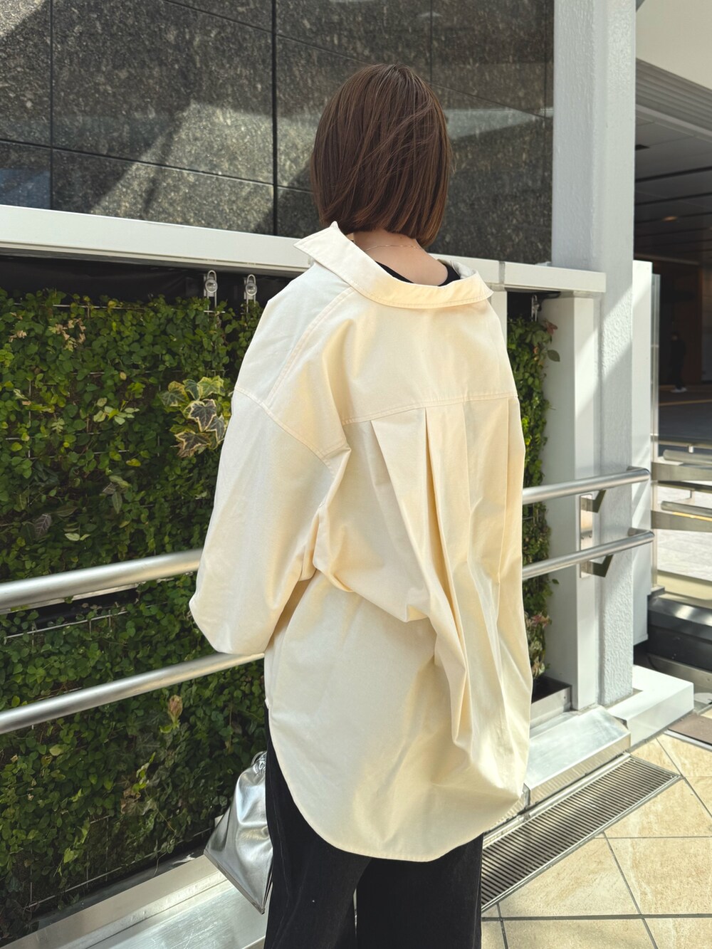 イエロー系のシャツ/ブラウス、シルバー系のショルダーバッグ、シルバー系のサンダルを着用したレディースの春コーディネートの4枚目の写真