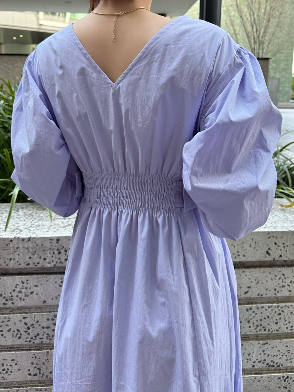 ホワイト系のハンドバッグ、ホワイト系のスニーカー、ブルー系のワンピースを着用したレディースの冬コーディネートの5枚目の写真