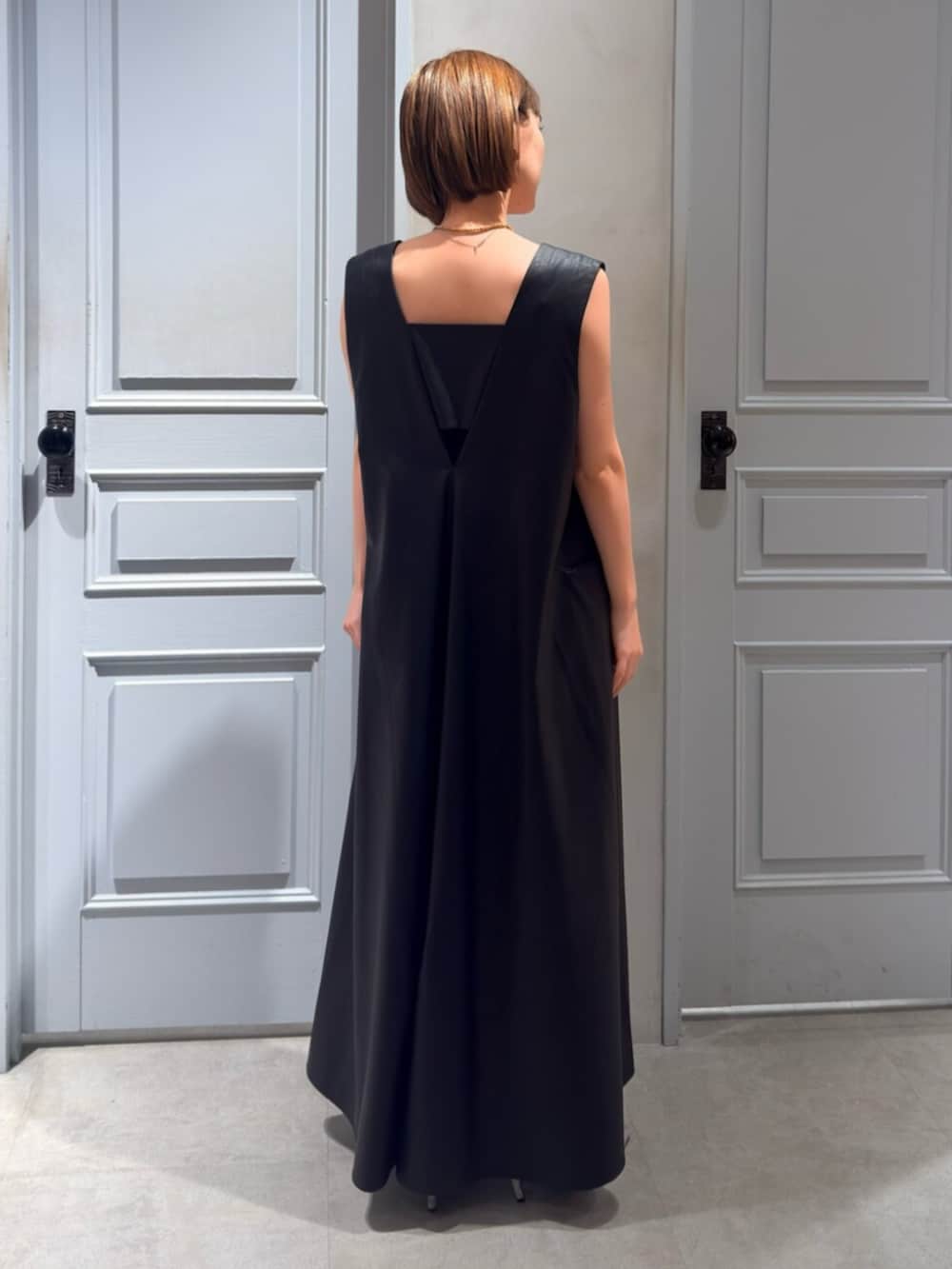 シルバー系のパンプス、ブラック系のワンピースを着用したレディースの春コーディネートの3枚目の写真