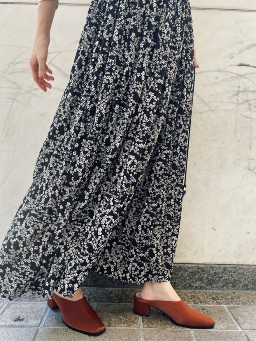 ブラック系のハンドバッグ、ブラック系のワンピース、オレンジ系のスリッポンを着用したレディースの夏コーディネートの5枚目の写真