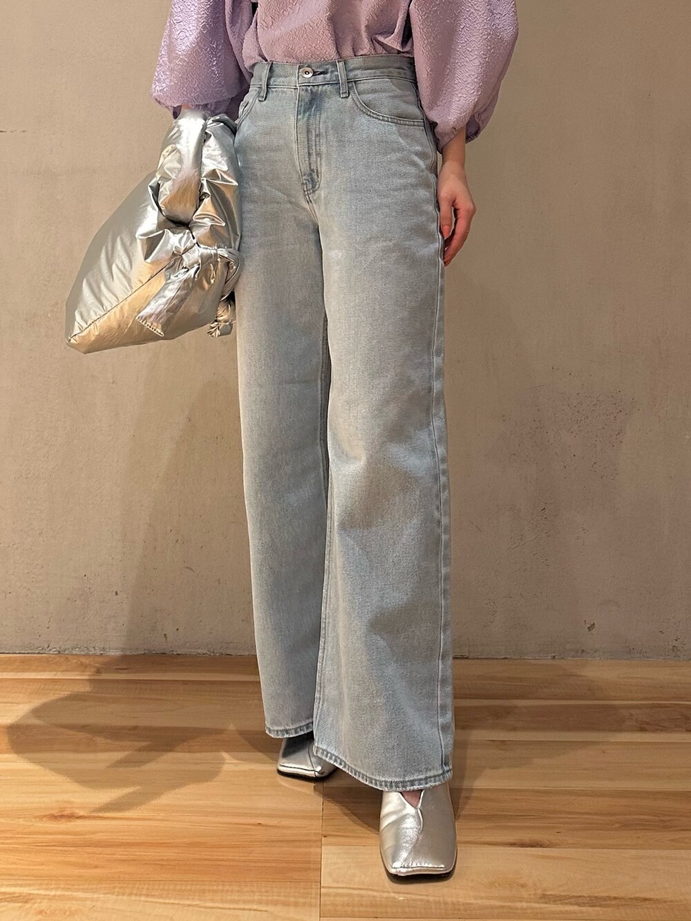 ブルー系のデニムパンツ、シルバー系のパンプス、パープル系のブルゾンを着用したレディースの冬コーディネートの6枚目の写真