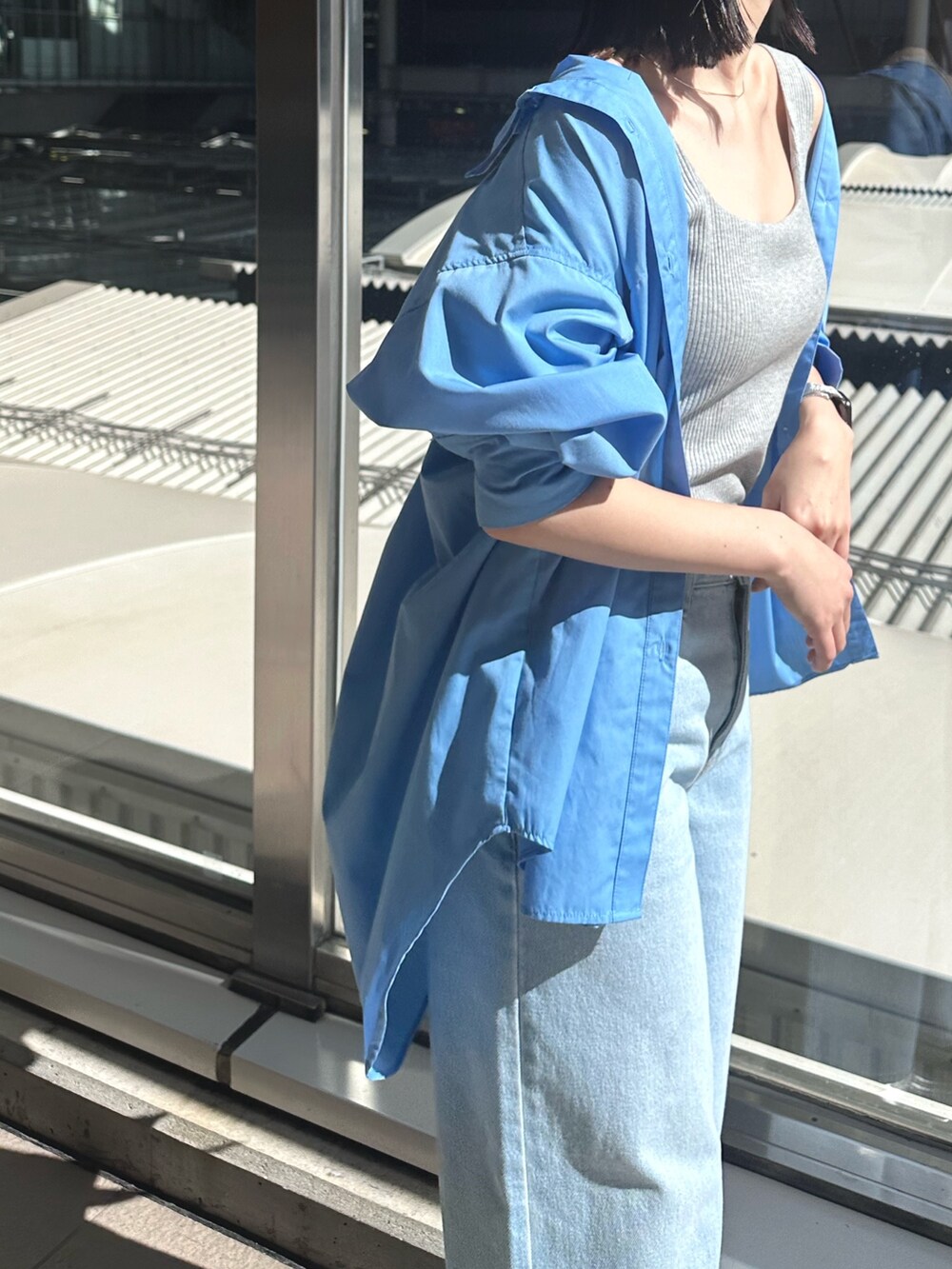 ブルー系のデニムパンツ、シルバー系のパンプス、グレー系のタンクトップを着用したレディースの春コーディネートの8枚目の写真